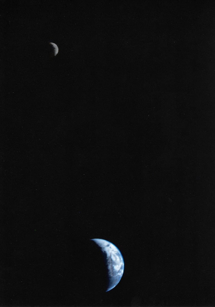Earth and the Moon as two thin crescents in black space, the blue-and-white Earth near the bottom and the small grey Moon near the top